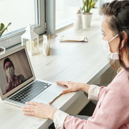 coronavirus woman working from home on video call with mask